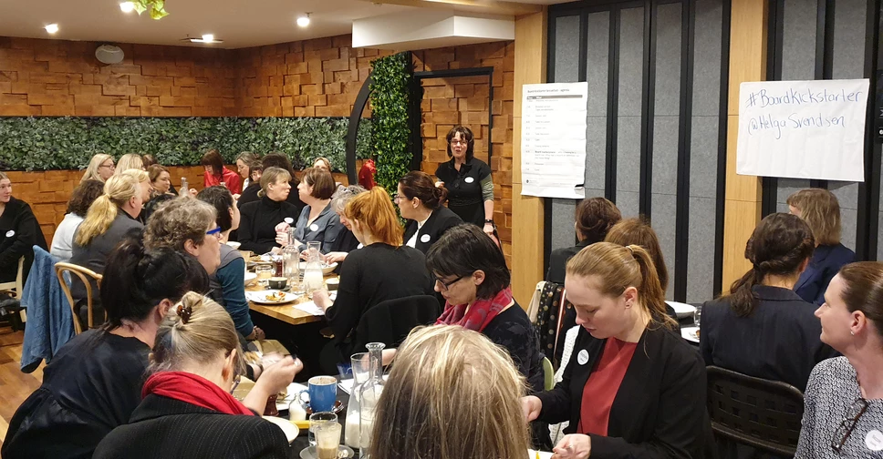 A very large group of women sit around breakfast tables, listening and taking notes, while I speak next to a whiteboard at the front of the room.