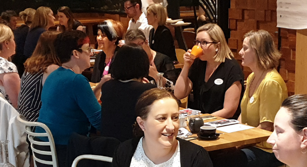 Up to 10 different women can be seen at different tables at November 2017's Take on Board breakfast, talking, listening, eating breakfast.