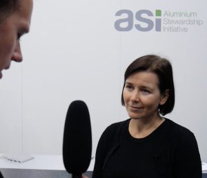 Fiona Solomon - ASI's CEO - stands in front of a microphone, waiting for the interviewer's next question.