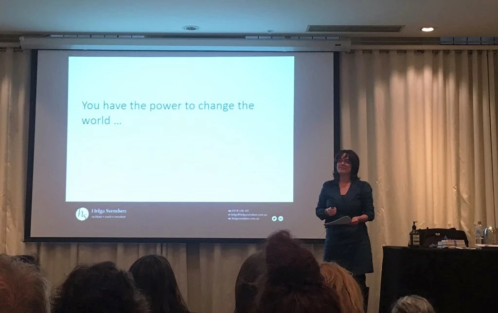 I'm presenting at the Victorian Regional Community Leadership program day. I'm standing in front of a seated audience in a darkened room, beside a project screen. 'You have the power to change the world' is written on the screen.